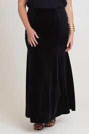 Model Chanel wearing size 16 of the Marlene Velvet Skirt in colour Black (Black), from the front, cropped image