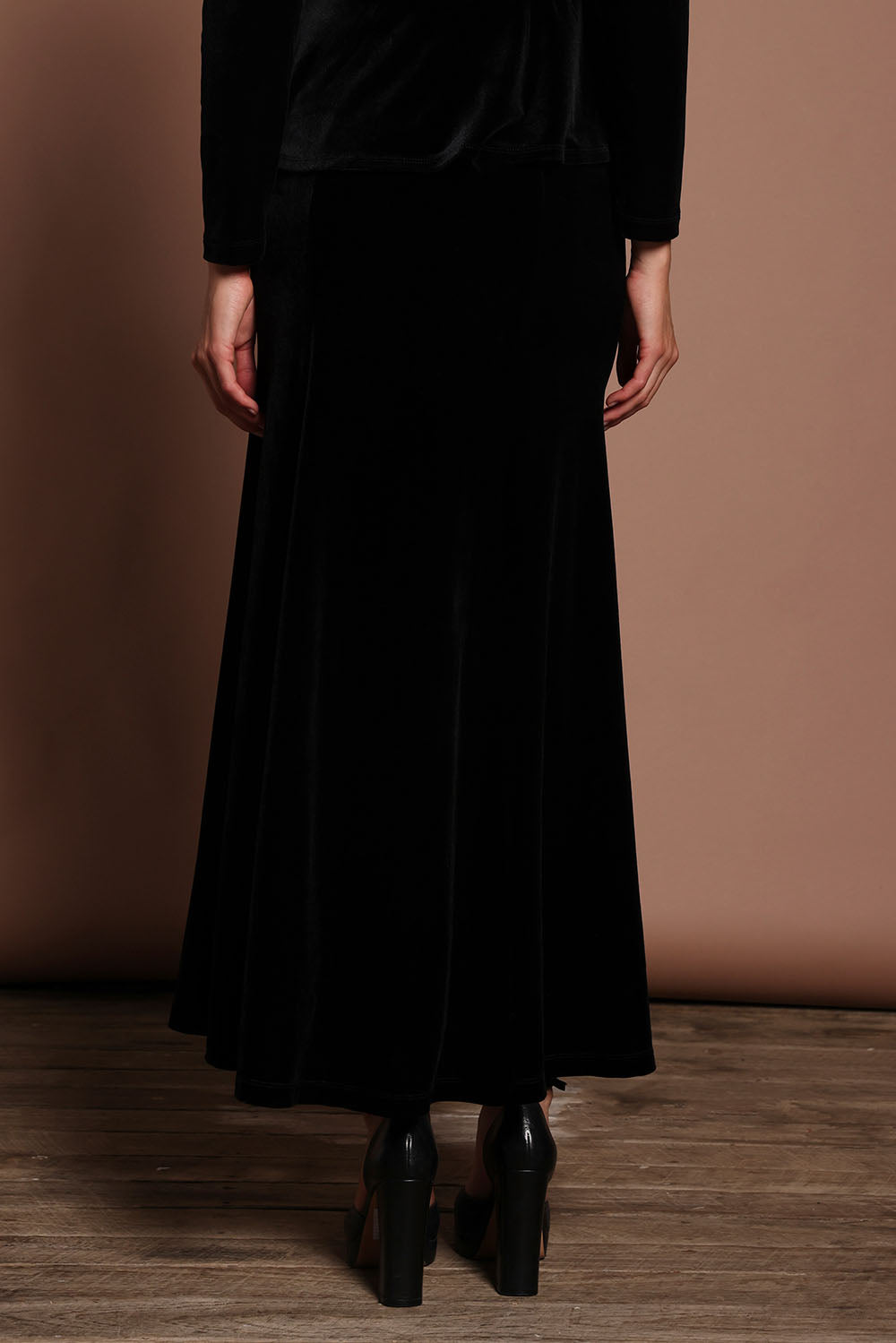 Model Madeline wearing size 10 of the Marlene Velvet Skirt in colour Black (Black), from the back