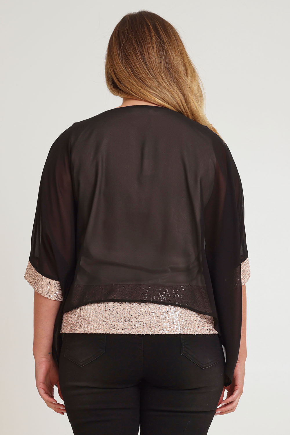 Model Chanel wearing size 16 of the Ria Top in colour Blackgold (Black), from the back