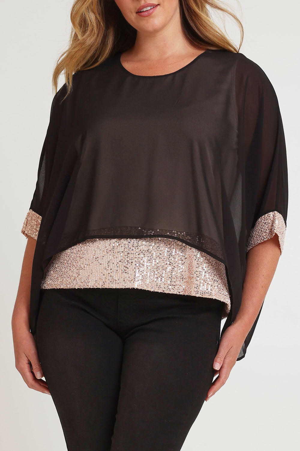 Model Chanel wearing size 16 of the Ria Top in colour Blackgold (Black), from the front, cropped image