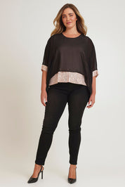 Model Chanel wearing size 16 of the Ria Top in colour Blackgold (Black), from the front, showing the whole outfit