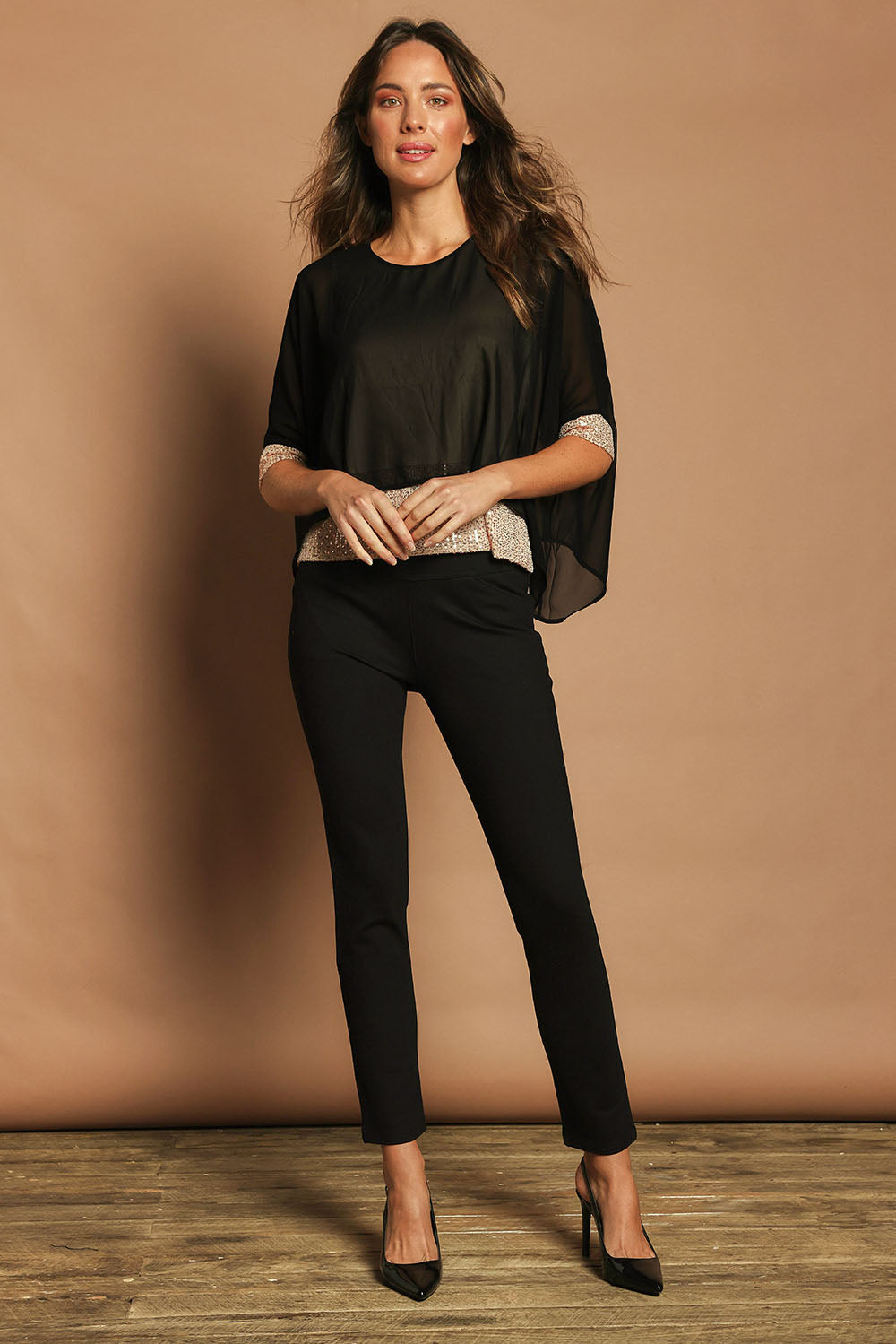 Model Madeline wearing size 10 of the Ria Top in colour Blackgold (Black), from the front, showing the whole outfit