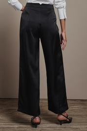 Model Madeline wearing size 10 of the Amelia Pants in colour Black (Black), from the back
