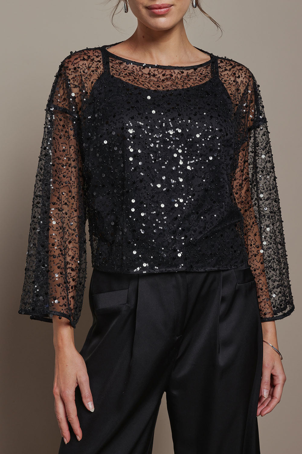 Model Madeline wearing the Nina Sequin Top in colour Black (Black), from the front, cropped image