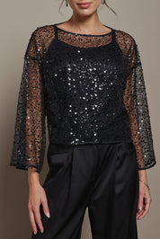 Model Madeline wearing the Nina Sequin Top in colour Black (Black), from the front, cropped image