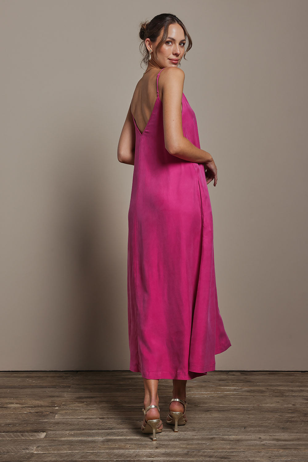 Model Madeline wearing size 10 of the Edith Dress in colour Magenta (Pink), from the back