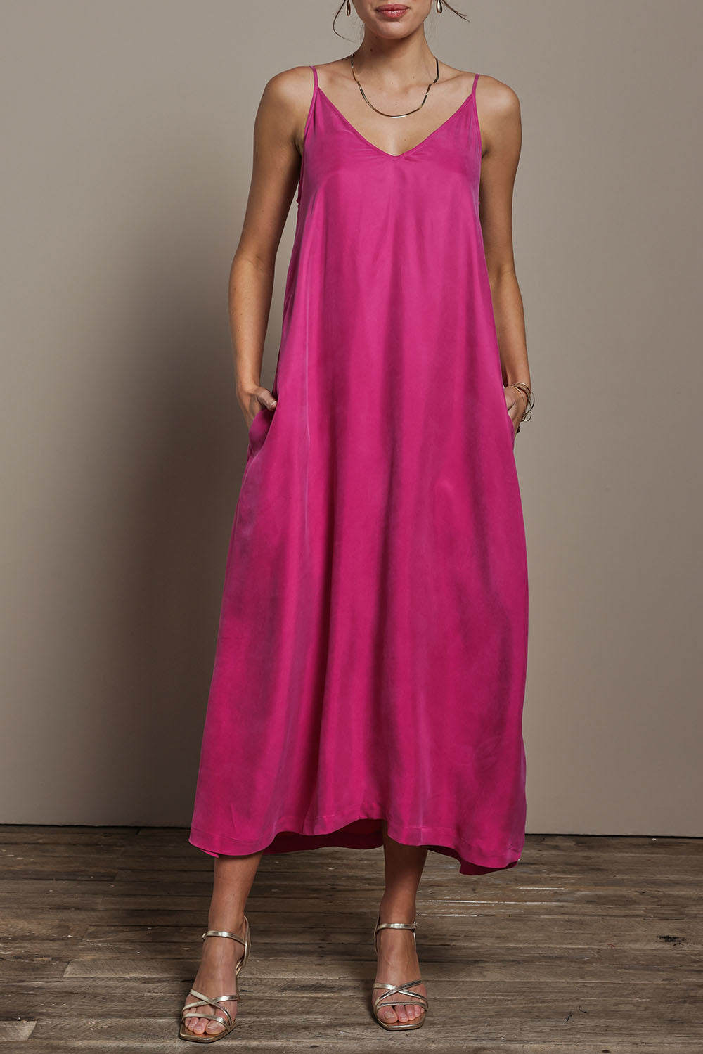 Model Madeline wearing size 10 of the Edith Dress in colour Magenta (Pink), from the front, cropped image