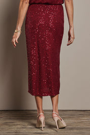 Model Amanda wearing size 10 of the Reegan Sequin Skirt in colour Rouge (Metallics), from the back