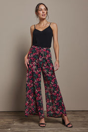 Model Madeline wearing size 10 of the Annette Pants in colour Blossom (Black), from the front, showing the whole outfit