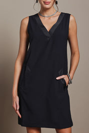 Model Madeline wearing size 10 of the Meave Tuxedo Dress in colour Black (Black), from the front, cropped image