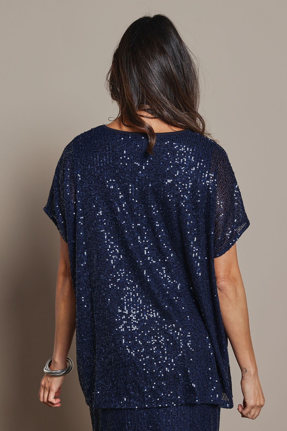 Model Amanda wearing size 10 of the Renee Sequin Top in colour Navy (Metallics), from the back