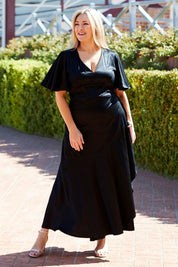 Model Ljubenka wearing size 18 of the Fleur Dress in colour Black (Black), from the front, showing the whole outfit