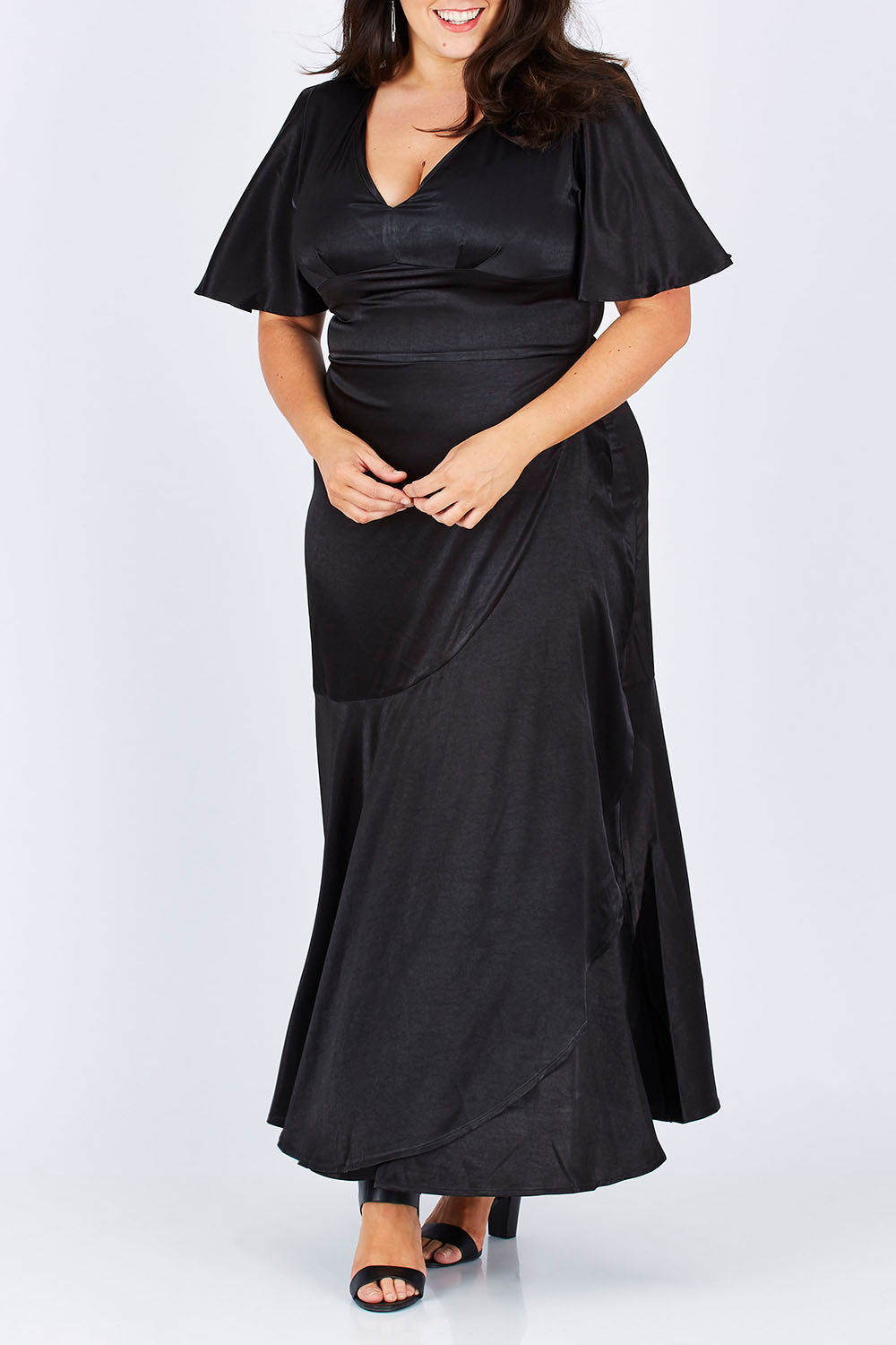 Model Mae wearing size 18 of the Fleur Dress in colour Black (Black), from the front, cropped image