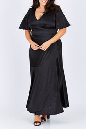 Model Mae wearing size 18 of the Fleur Dress in colour Black (Black), from the front, cropped image