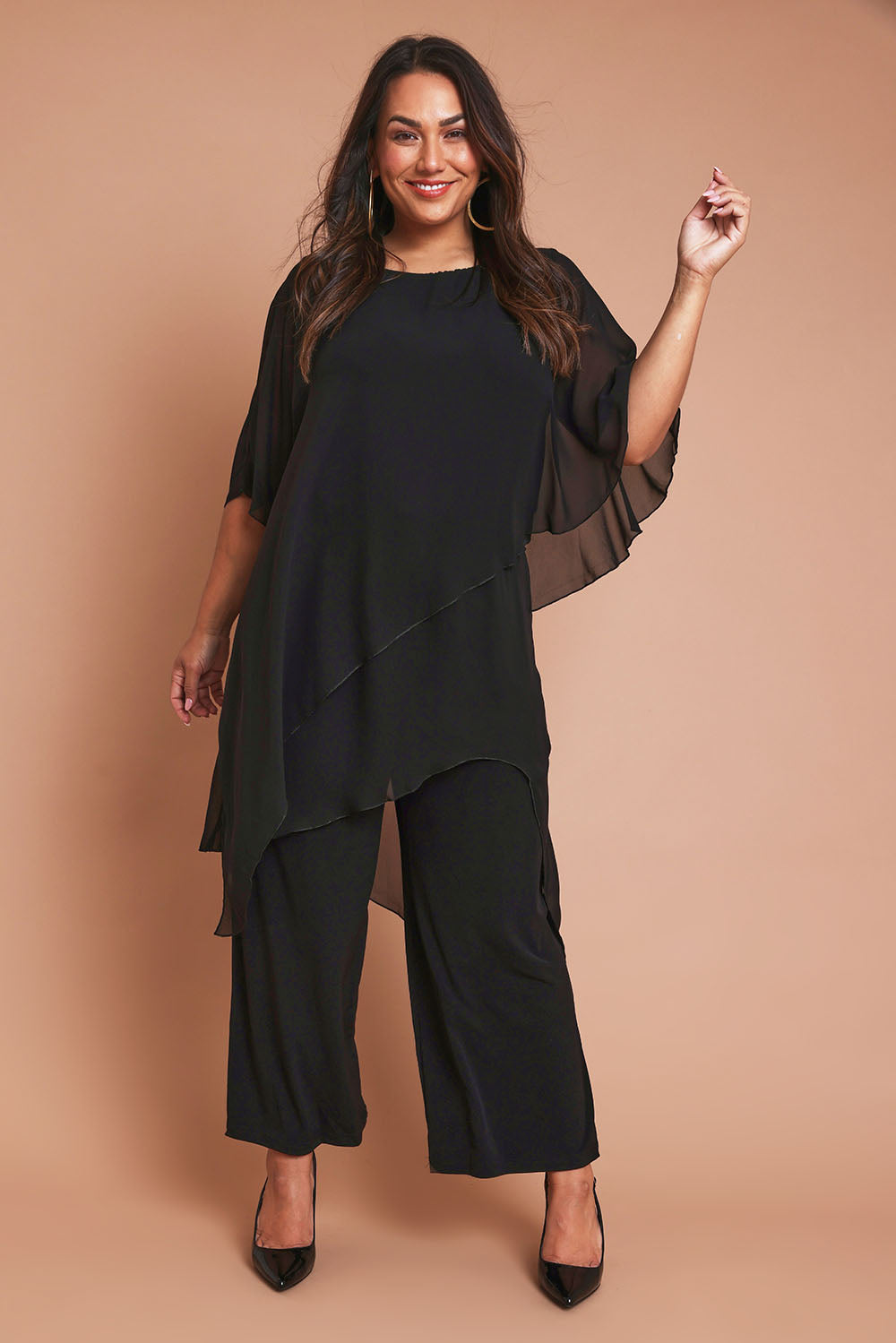 Model Ashleigh wearing size 16 of the Sandra Jumpsuit in colour Black (Black), from the front, showing the whole outfit