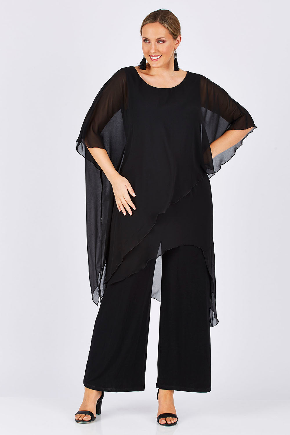 Model Jess wearing size 14 of the Sandra Jumpsuit in colour Black (Black), from the front, showing the whole outfit