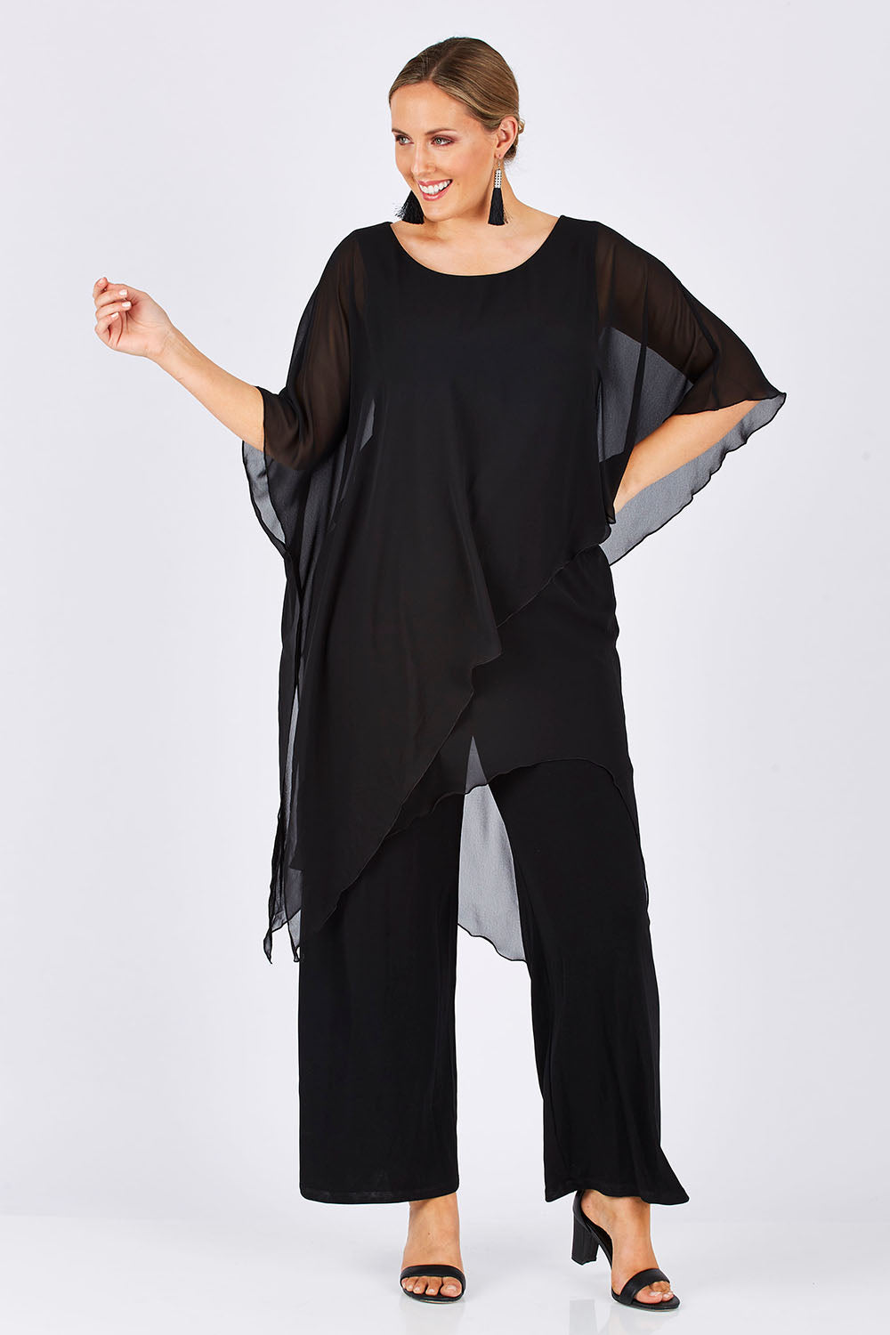 Model Jess wearing size 14 of the Sandra Jumpsuit in colour Black (Black), from the front, showing the whole outfit
