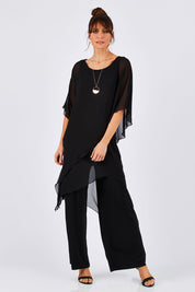 Model Monique wearing size 8 of the Sandra Jumpsuit in colour Black (Black), from the front, showing the whole outfit