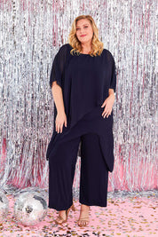 Model Caitlin wearing size 20 of the Sandra Jumpsuit in colour Navy (Blue), from the front, showing the whole outfit