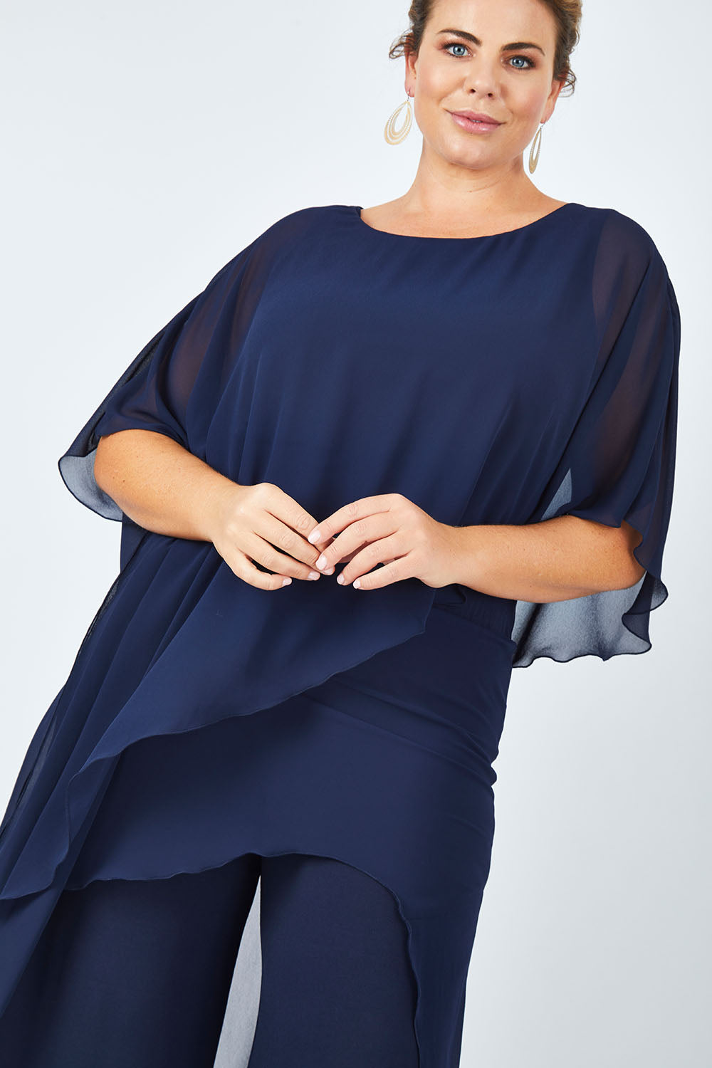 Model Fiona wearing size 16 of the Sandra Jumpsuit in colour Navy (Blue), from the front, cropped image