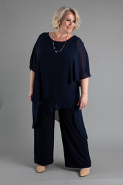 A model wearing size 18 of the Sandra Jumpsuit in colour Navy (Blue), from the front, showing the whole outfit