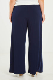 Model Katie wearing size 16 of the Kristi Pants in colour Navy (Blue), from the back
