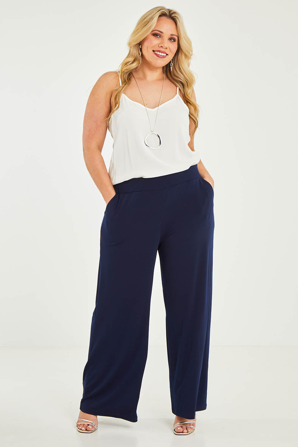 Model Katie wearing size 16 of the Kristi Pants in colour Navy (Blue), from the front, showing the whole outfit