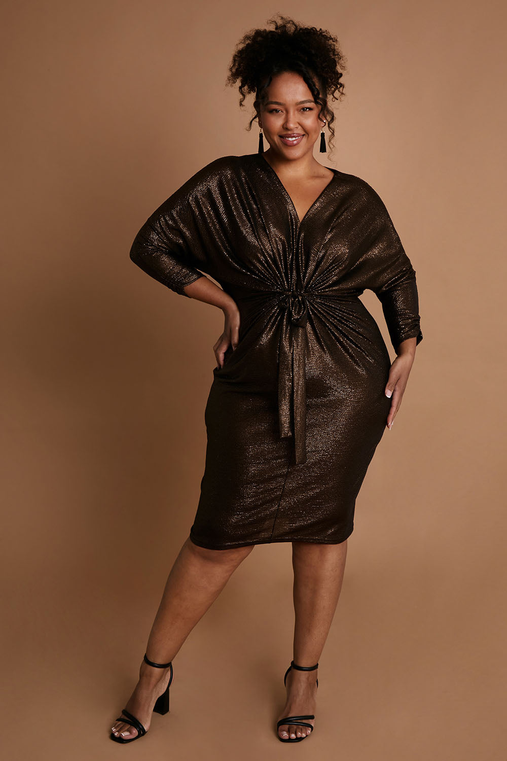 Model Alexis wearing size 16 of the Nancy Dress in colour Bronze (Metallics), from the front, showing the whole outfit