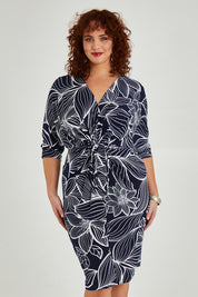 Model Maddy wearing size 16 of The Printed Nancy Dress in colour Navyleaves (Blue), from the front, cropped image