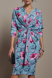 Model Madeline wearing size 10 of The Printed Nancy Dress in colour Windflower, from the front, cropped image