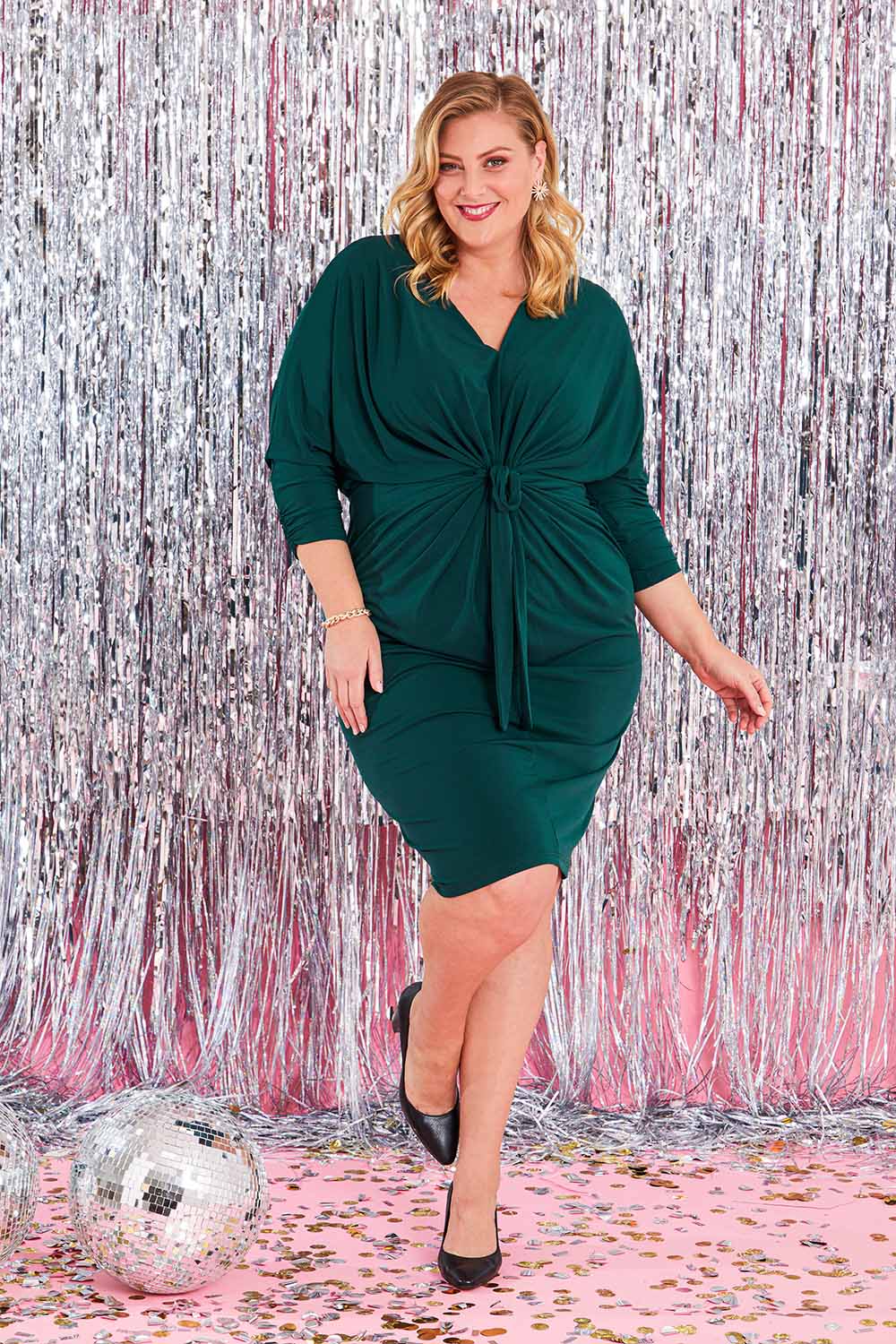 Model Caitlin wearing size 20 of the Nancy Dress in colour Forest (Green), from the front, showing the whole outfit