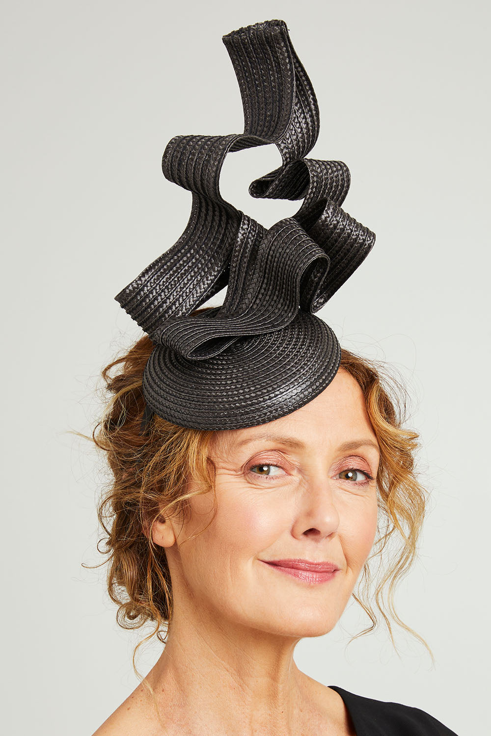 Model Emma wearing size OneSize of the Nalah Fascinator in colour Black (Black), from the front, showing the whole outfit