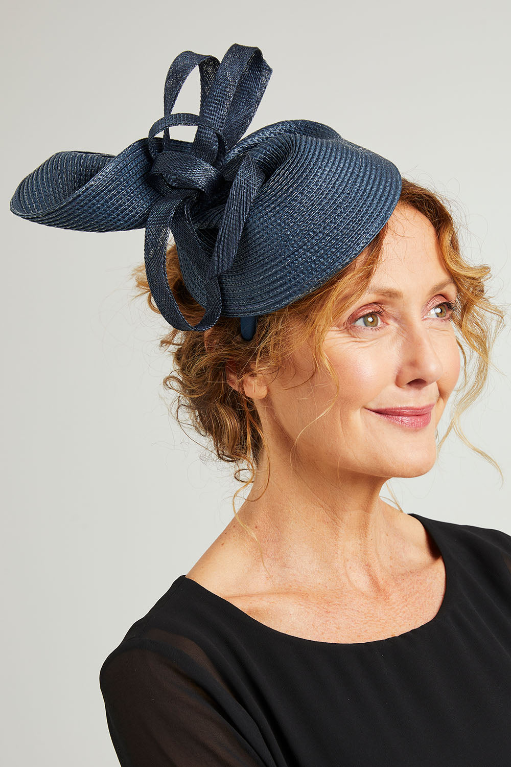 Model Emma wearing size OneSize of the Drew Fascinator in colour Navy (Blue), from the front, showing the whole outfit
