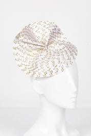 A model wearing size OneSize of the Zaria Fascinator in colour Ivorygold (White), from the front, showing the whole outfit