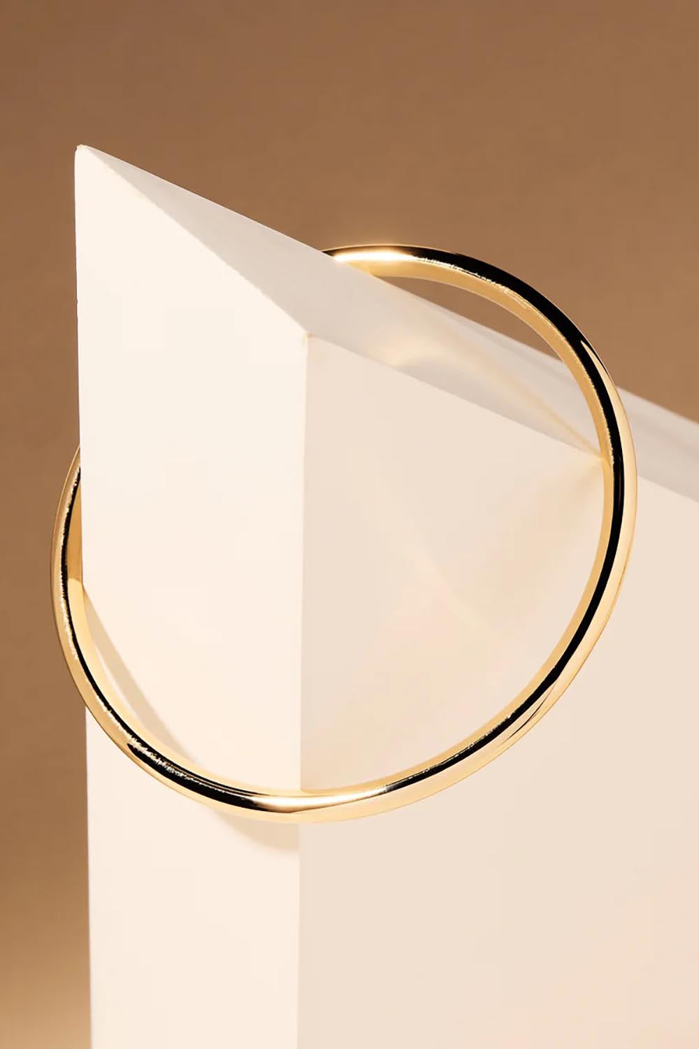 A model wearing the Simplicity Gold Bangle in colour Gold (Metallics), from the front, showing the whole outfit