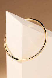 A model wearing the Simplicity Gold Bangle in colour Gold (Metallics), from the front, showing the whole outfit