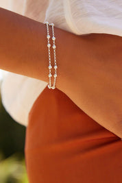 A model wearing the Mattina Silver Bracelet in colour Silver (Metallics), from the front, cropped image