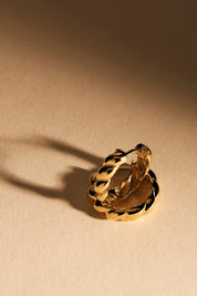 A model wearing the Zippy Twist Huggie Earrings in colour Gold (Metallics), from the front, showing the whole outfit