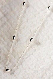 A model wearing the Like A Breeze Necklace in colour Silver (Metallics), from the front, showing the whole outfit