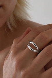 A model wearing the Creation Silver Ring in colour Silver (Metallics), from the front, cropped image