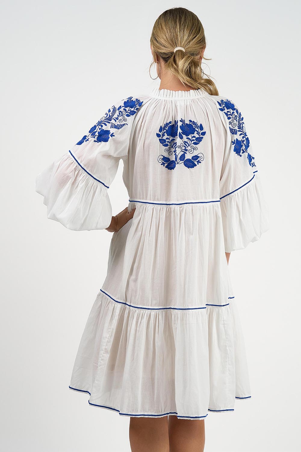 A model wearing the Molly Cotton Dress in colour Elsa (White), from the back