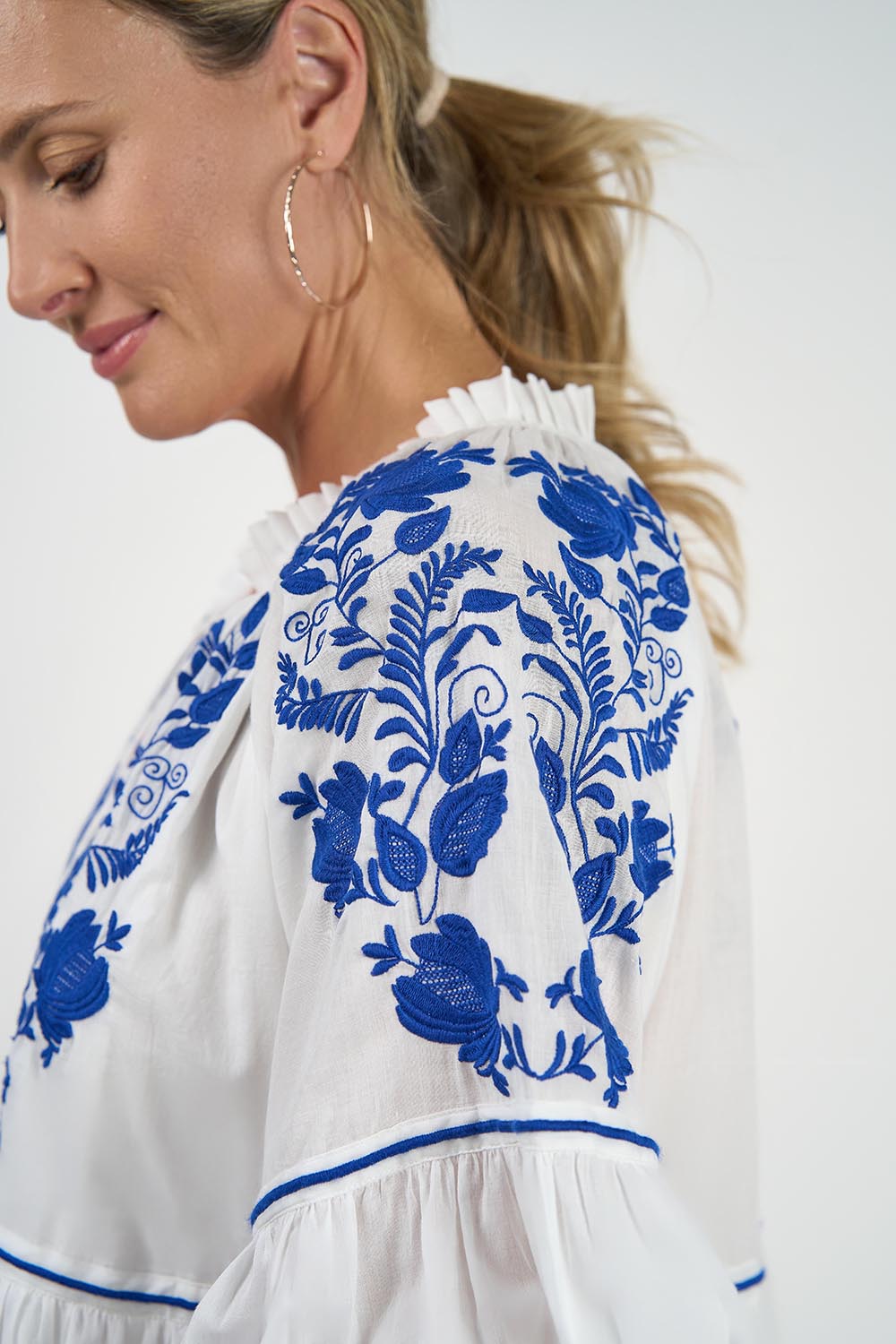 A model wearing the Molly Cotton Dress in colour Elsa (White), from the front, cropped image