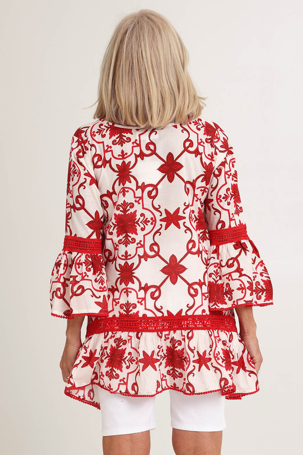 Model Sandy wearing size S of the Hacienda Cotton Tunic in colour Jemmared (Red), from the back