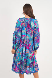 A model wearing the Molly Dress in colour Enigma (Blue), from the back