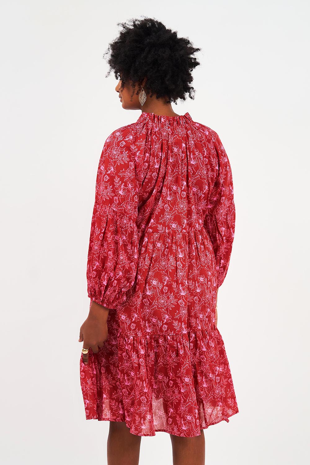 A model wearing the Molly Cotton Dress in colour Serenityma (Red), from the back