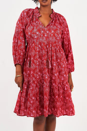 A model wearing the Molly Cotton Dress in colour Serenityma (Red), from the front, cropped image