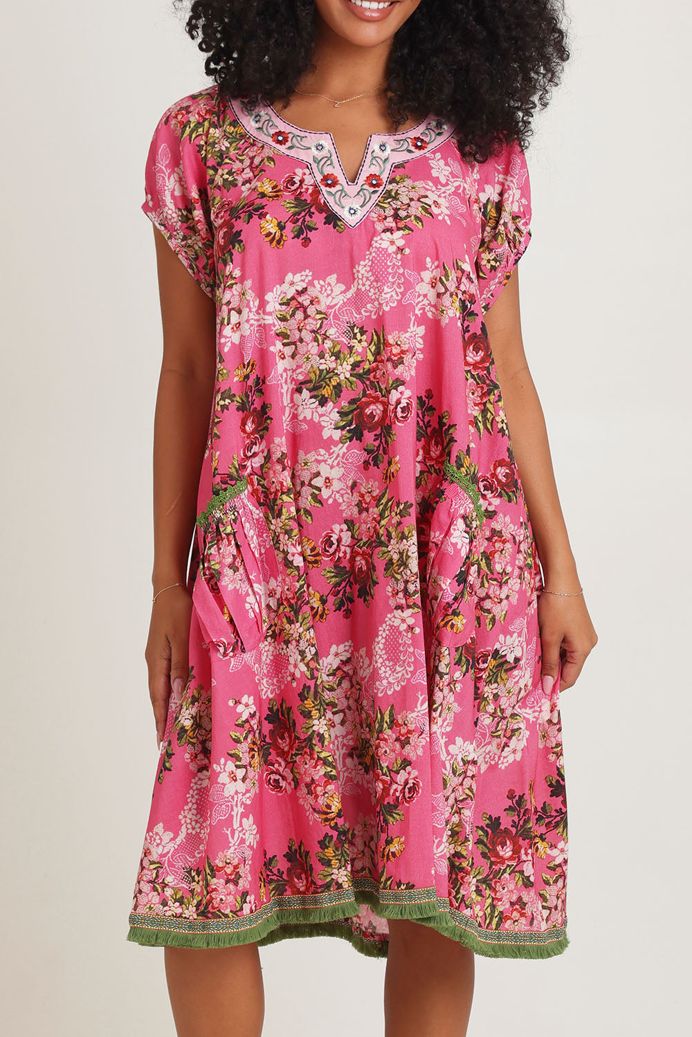 Model Ziara wearing size S of the Sao Paulo Cotton Dress in colour Folly (Pink), from the front, cropped image