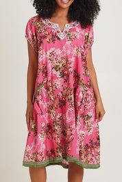 Model Ziara wearing size S of the Sao Paulo Cotton Dress in colour Folly (Pink), from the front, cropped image