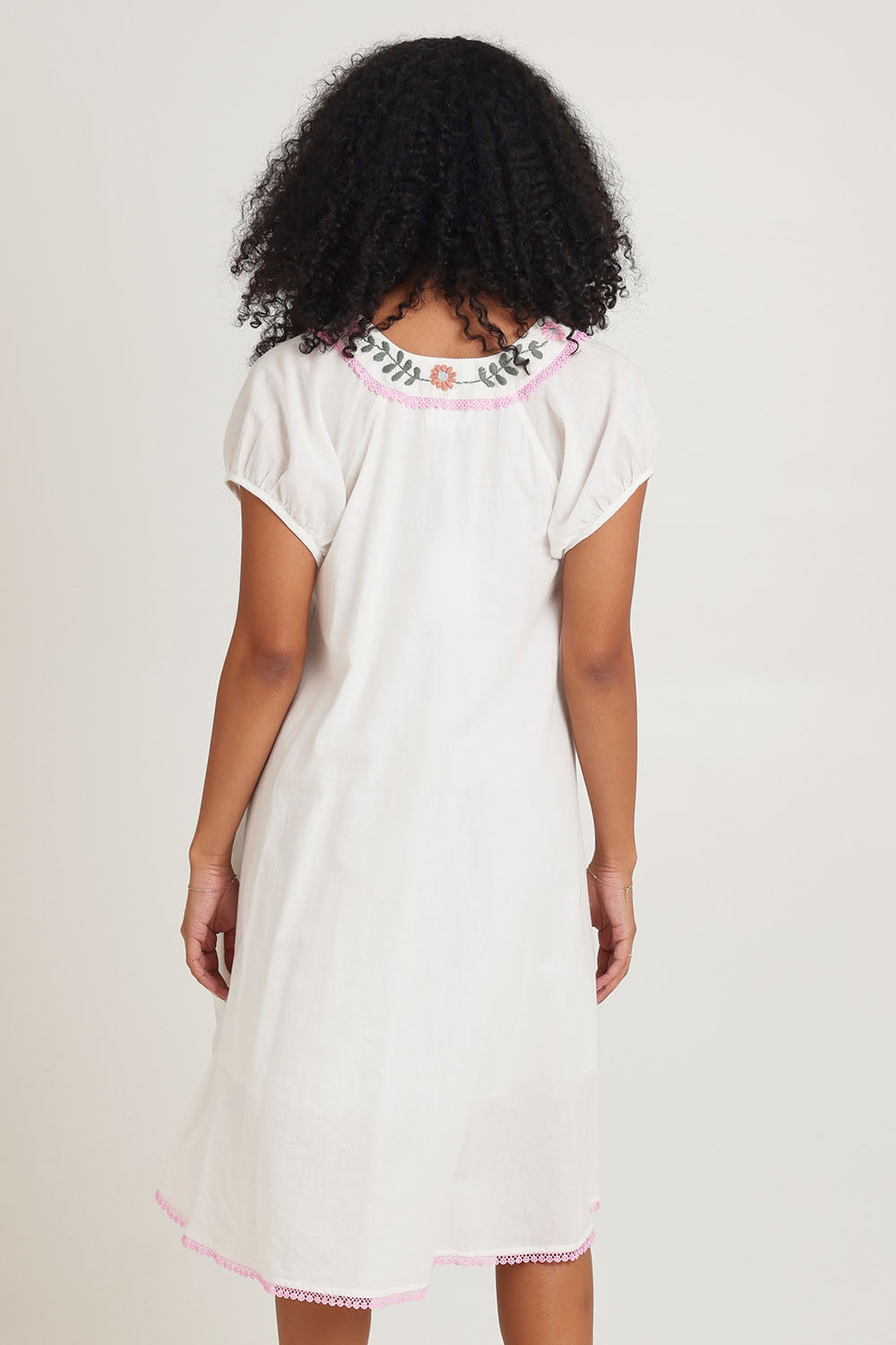 Model Ziara wearing size S of the Sao Paulo Cotton Dress in colour Jewel (White), from the back