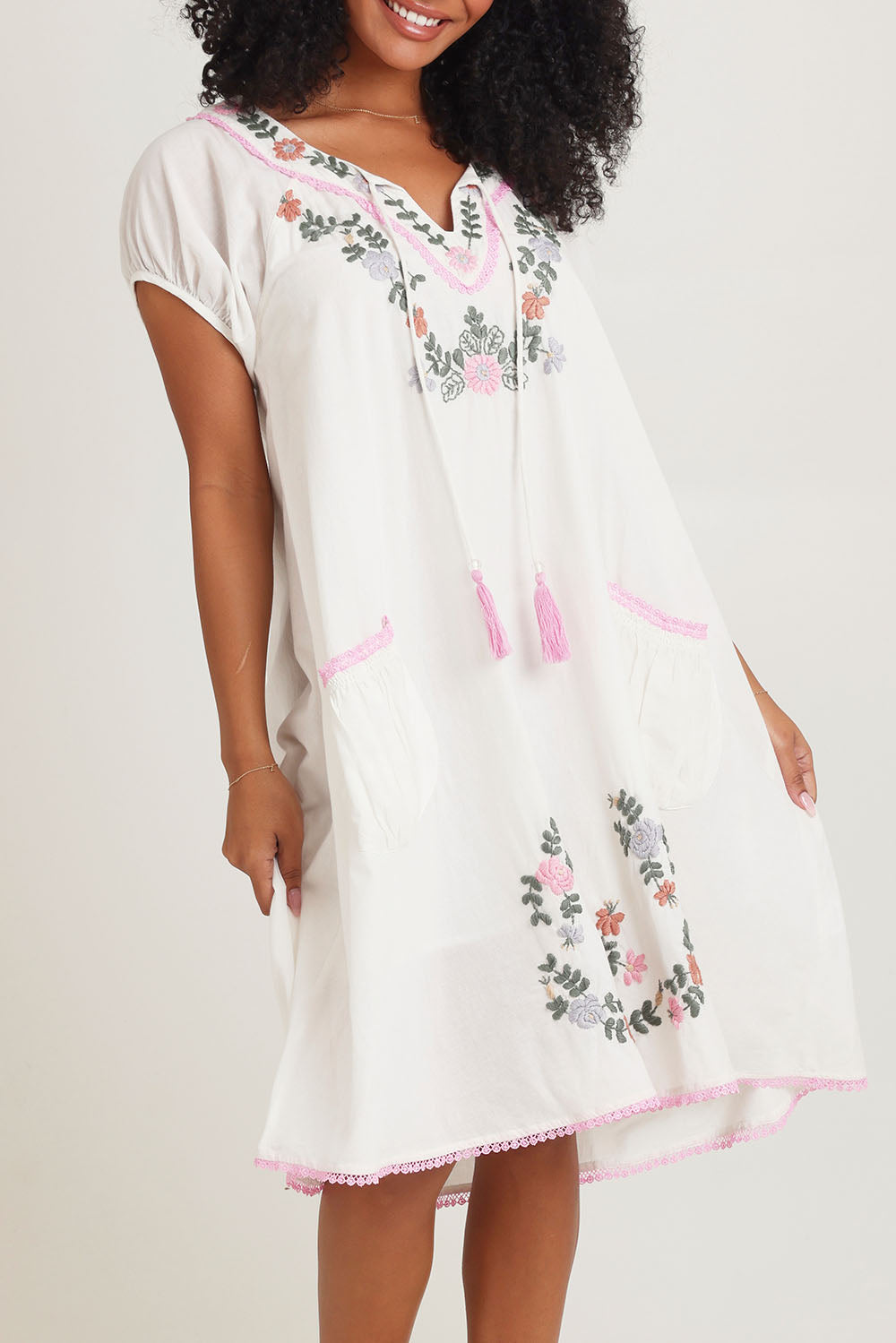 Model Ziara wearing size S of the Sao Paulo Cotton Dress in colour Jewel (White), from the front, cropped image